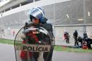 In this May 17 2015 photo, a riot policeman holds a crying boy as his father is attacked by other policemen with batons, right, outside of a stadium, in Guimaraes, Portugal. Portuguese prosecutors are investigating a policeman who beat a man in front of his young children and punched their grandfather outside a soccer stadium, sparking a national scandal. Police approached Jose Magalhaes, his two sons and his father Sunday outside Guimaraes stadium, where Benfica had just won the Portuguese league title, according to film footage and witness reports. (AP Photo/Delfim Machado)