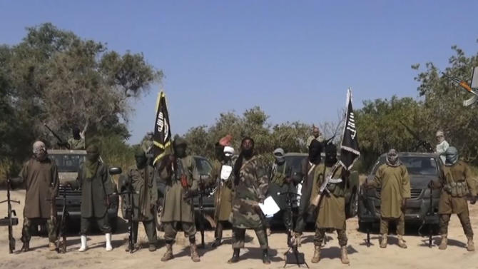 An image grab made on October 31, 2014 from a video obtained by AFP shows the leader of the Islamist extremist group Boko Haram, Abubakar Shekau (C), delivering a speech