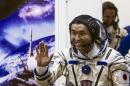 Wakata waves after donning a space suit shortly before the blast off for the ISS, at the Baikonur cosmodrome