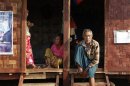 Ethnic Kachin people sit in the doorways of shelters at a temporary camp for people displaced by fighting between government troops and the Kachin Independence Army, or KIA, outside the city of Myitkyina
