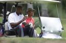 President Barack Obama, right, rides in a golf cart with former NBA basketball player Alonzo Mourning, left, while golfing at Farm Neck Golf Club, in Oak Bluffs, Mass., on the island of Martha's Vineyard, Saturday, Aug. 23, 2014. Obama is vacationing on the island. (AP Photo/Steven Senne)