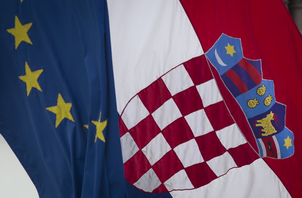 A Croatian, right, and a EU flag fly in downtown in Zagreb, Croatia, Sunday, June 30, 2013. Croatia is to join the European Union on July 1, 2013. (AP Photo/Darko Bandic)