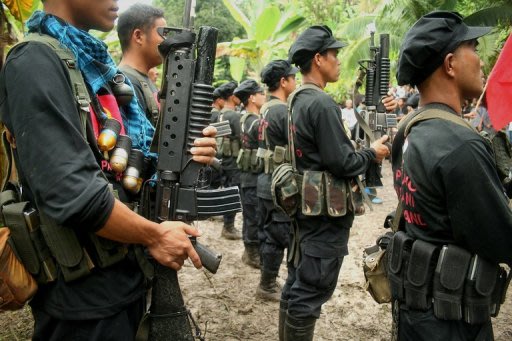 Members of the rebel New People's Army stand in formation during the 40th anniversary celebrations of the Communist Party of the Philippines inside a remote camp in Davao, in the southern Island of Mindanao. Philippine communist guerrillas have killed 11 soldiers and a civilian in one of their most audacious attacks in recent years, the military said