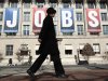 Woman walks past "Jobs" banner hung above Chamber of Commerce in Washington