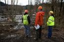 Snohomish County officials evaluate the scene left by a mudslide in Oso