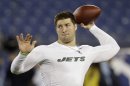 FILE - In this Dec. 17, 2012, file photo, then-New York Jets quarterback Tim Tebow warms up before an NFL football game in Nashville, Tenn. Tim Tebow is joining the New England Patriots, according to a report by ESPN on Monday, June 10, 2013. The high-profile quarterback who spent one season mostly on the sidelines with the New York Jets is expected to attend the start of the Patriots three-day minicamp on Tuesday. (AP Photo/Wade Payne, File)