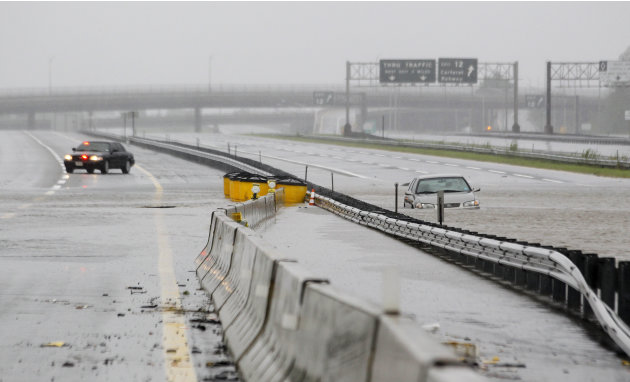 An abandoned car is half-submerged in a southbound lane of the New Jersey Turnpike near exit 12 as floodwaters from Hurricane Irene cover the road Sunday, Aug. 28, 2011, in Carteret, N.J. (AP Photo/Ju