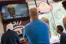 People watch a television at Dunkin Donuts as New England Patriots tight end Aaron Hernandez is arraigned next door in the Attleborough District Court