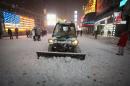 A snow plow pushes snow through Times Square in New York