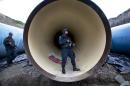 Federal police guard a drainage pipe outside of the Altiplano maximum security prison in Almoloya, west of Mexico City, Sunday, July 12, 2015. Mexico's most powerful drug lord, Joaquin "El Chapo" Guzman, escaped from a maximum security prison through a tunnel that opened into the shower area of his cell, the country's top security official announced. (AP Photo/Marco Ugarte)