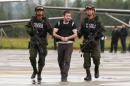 Police escort Colombian drug trafficker Daniel 'El Loco' Barrera as he is brought before the media, before being extradited to the U.S., at an airport in an anti-narcotics base in Bogota