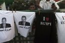 A boy stands near t-shirts with images of elected president Mursi during a sit-in in Cairo