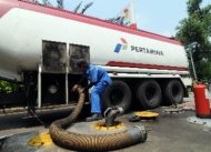 Petugas memasang alat pengisian bahan bakar minyak (BBM) premium dari tanki di SPBU Abdul Muis, Jakarta.