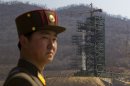 A North Korean soldier stands in front of the country's Unha-3 rocket, slated for liftoff between April 12-16, at a launching site in Tongchang-ri, North Korea on Sunday April 8, 2012. North Korean space officials have moved a long-range rocket into position for this week's controversial satellite launch, vowing Sunday to push ahead with their plans in defiance of international warnings against violating a ban on missile activity.(AP Photo/David Guttenfelder)