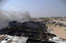 Smoke rises from a milk factory hit by an air strike in Yemen's western port city of Houdieda