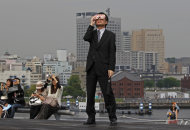 A business man watches an annular solar eclipse at a waterfront park in Yokohama, near Tokyo, Monday, May 21, 2012. Millions of Asians watched as a rare "ring of fire" eclipse crossed their skies early Monday. The annular eclipse, in which the moon passes in front of the sun leaving only a golden ring around its edges, was visible to wide areas across the continent. (AP Photo/Shuji Kajiyama)