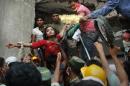 FOR USE AS DESIRED, YEAR END PHOTOS - FILE - A Bangladeshi woman survivor is lifted out of the rubble by rescuers at the site of a building that collapsed Wednesday in Savar, near Dhaka, Bangladesh, Thursday, April 25, 2013. This image was chosen by the Associated Press as one of the top 10 news photos representing the top stories of 2013. (AP Photo/Kevin Frayer, File)
