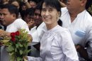 ALTERNATE CROP OF MYN101 - Myanmar pro-democracy leader Aung San Suu Kyi, center, arrives at the headquarters of her National League for Democracy party Monday, April 2, 2012, in Yangon, Myanmar. Suu Kyi said she hopes her victory in a landmark election will mark the beginning of a new era for Myanmar. Suu Kyi spoke to thousands of supporters Monday outside her opposition party headquarters, a day after her party claimed she had won a parliamentary seat in closely watched by-elections.(AP Photo/Khin Maung Win)