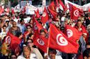 Tunisians wave their national flag as they march outside the National Assembly in Tunis on September 7, 2013