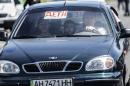 People drive their car showing a sign reading "children" as they leave their home on July 28, 2014 in Donetsk