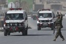 Ambulances arrive outside the Afghan Defense Ministry after a suicide bomber on a bicycle struck outside the ministry, killing at least nine Afghan civilians as U.S. Defense Secretary Chuck Hagel visited Kabul, Afghanistan, Saturday, March 9, 2013. (AP Photo/Anja Niedringhaus)