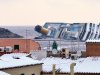 Snow covers the rooftops of the houses overlooking the harbour of the Tuscan island of Giglio, Italy, Saturday, Feb. 11, 2012, as the grounded Costa Concordia cruise liner still lays stricken in background. The Concordia ran aground on Jan. 13 after the captain deviated from his planned route and gashed the hull of the ship on a submerged reef.  (AP Photo/Paolo Fanciulli)