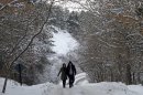 A couple walks on a snow covered road near the Lake of Eymir, Ankara, Turkey, on Sunday, Jan. 29, 2012. Winter temperatures and recent snowfall has partially paralyzed life in Turkey. (AP Photo/Selcan Hacaoglu)