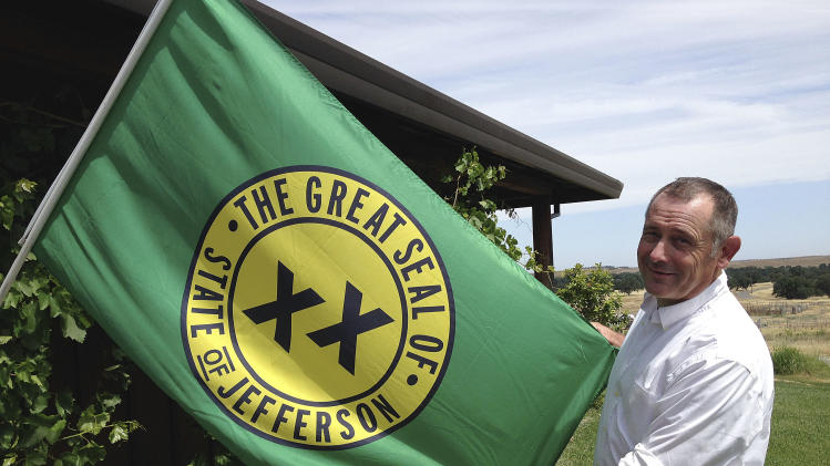 Tom Knorr, chairman of the Measure A campaign in Tehama County, holds a State of Jefferson flag as he poses for photographs at his ranch house in Corning, Calif., Tuesday, May 27, 2014. The idea of forming their own state has been a topic among local secession dreamers for more than a century in California’s largely rural, agrarian and politically conservative far northern counties. Residents in two counties, Del Norte and Tehama, will decide June 3, 2014, on an advisory measure that asks each county’s board of supervisors to join a wider effort to form a 51st state named Jefferson. (AP Photo/Terry Chea)