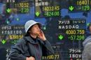 A woman passes before a share prices board in Tokyo on May 7, 2014