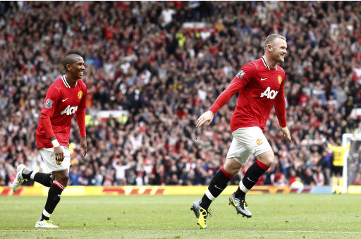 Manchester United's Wayne Rooney, right, celebrates with team mate Ashley Young after he scored a goal against Arsenal during their English Premier League soccer match at Old Trafford, Manchester, England, Sunday Aug. 28, 2011. (AP Photo/Jon Super)