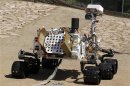 An engineering model of NASA's Curiosity Mars rover is seen from the rear in a sandy, Mars-like environment named the Mars Yard at NASA's Jet Propulsion Laboratory in Pasadena, California