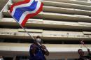 An anti-government protester waves a Thai national flag during a rally at the Department of Public Works and Town & Country Planning in Bangkok