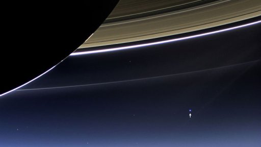Anéis de Saturno e o planeta Terra (marcado com uma seta)