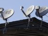 In this Feb. 23, 2011 photo, three Dish Network satellite dishes, attached near the roof line of an apartment complex is displayed in Palo Alto, Calif. Dish Network Corp.'s second-quarter net income climbed 30 percent Tuesday, Aug. 9, 2011, but its net subscribers declined partly because of rival's discounts. (AP Photo/Paul Sakuma)