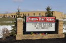 Bouquets of flowers sit on the sign in front of the high school in Chardon, Ohio Tuesday, Feb. 28, 2012. A gunman opened fire inside the school's cafeteria at the start of the school day Monday. Two of the victims have died and three remain hospitalized (AP Photo/Mark Duncan)