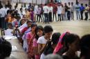 Indian voters wait in queues to cast their votes during the first phase of elections in Dibrugarh, in the northeastern state of Assam, India, Monday, April 7, 2014. Indians began voting Monday in the world's biggest election, with the opposition heading into the polls with strong momentum on promises of economic renewal. The country's 814 million eligible voters will vote in stages over the next five weeks. (AP Photo/Altaf Qadri)