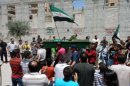 An image released by the Shaam News Network, shows the funeral procession of Yasser Raqiyeh in Aleppo on June 5