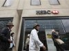 Tourists pass an HSBC bank in central London