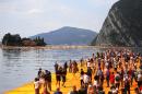 People walk on the monumental installation entitled 'The Floating Piers' created by artist Christo Vladimirov Javacheff on Iseo Lake, in northern Italy, on June 18, 2016