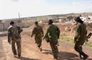 Forces loyal to Syria's President Assad walk in Khan al-Assal area near the northern city of Aleppo, near the site where a chemical weapon attack occured on Tuesday
