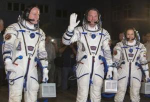 The International Space Station crew of Barry Wilmore of the U.S., Alexander Samokutyaev and Elena Serova of Russia walk after donning space suits at the Baikonur cosmodrome