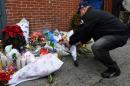 People leave items at a memorial near Tompkins Ave and Myrtle Ave on December 21, 2014 in New York near the site where two New York City police officers were shot and killed