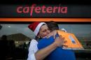 Gas station worker, Maria Gonzalez Jimenez, hugs a colleague after winning the second prize of the Christmas lottery 