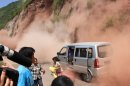 People run as fallen rocks land near their vehicle after the area was hit by earthquake in Zhaotong town, Yiliang County, southwest China's Yunnan Province, Friday, Sept. 7, 2012. A series of earthquakes collapsed houses and triggered landslides Friday in a remote mountainous part of southwestern China where damage was preventing rescues and communications were disrupted. At least 64 deaths have been reported. (AP Photo) CHINA OUT