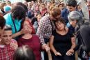 Family members of Korkmaz Tedik, a victim of Saturday's bomb blasts, mourn over his coffin during a funeral ceremony in Ankara