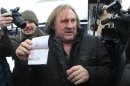French film star Depardieu shows his passport after arriving at the airport in the town of Saransk