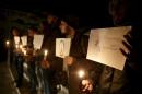 Residents carry candles and placards in tribute to the victims of the Paris attacks in the town of Duma, eastern Ghouta in Damascus
