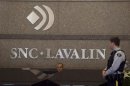 Royal Canadian Mounted Police officer looks at a receptionist at the headquarters of SNC Lavalin in Montreal