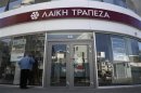 A man tries to look inside a branch of Laiki Bank a few hours before the reopening of the banks on the island in Nicosia