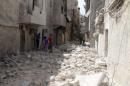 Residents inspect damages after an airstrike on the rebel held al-Maysar neighborhood in Aleppo